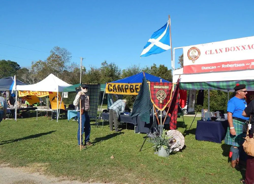 Scottish clan tents and visitors at an outdoor gathering
